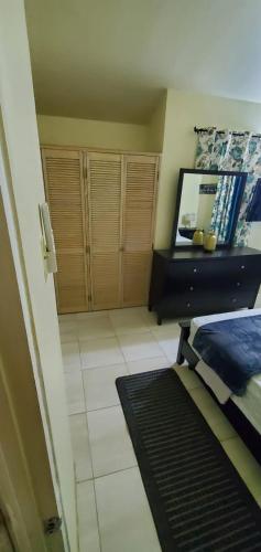 a room with a bedroom with a mirror and a bed at Finest Accommodation Phoenix Park Phase 1 Lot 74 Portmore St Catherine in Portmore