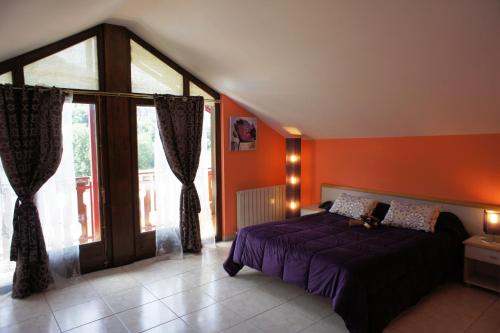 sypialnia z fioletowym łóżkiem i dużym oknem w obiekcie Hotel La Planada w mieście Ordino
