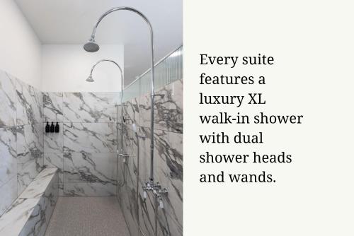 a bathroom with a shower with marble floors and walls at The Atlee Suites in Millersburg