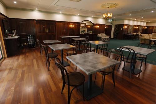 a restaurant with tables and chairs in a room at The Lawson Riverside Suites in Wagga Wagga