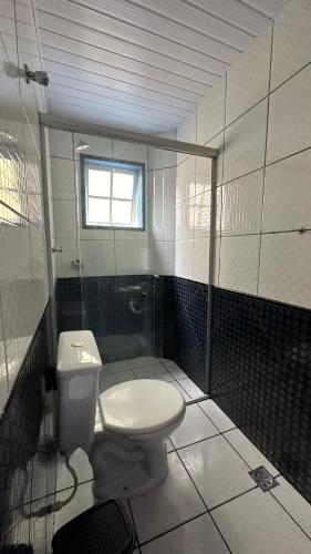 a bathroom with a toilet and a window at Escadaria Vila Rica Pousada & Hostel in Ouro Preto