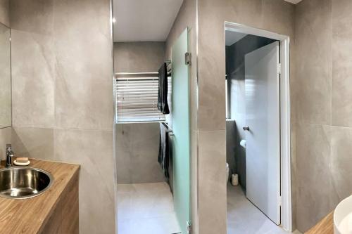 a small bathroom with a sink and a mirror at Ultimate Coastal Escape + Amazing Views in Caloundra