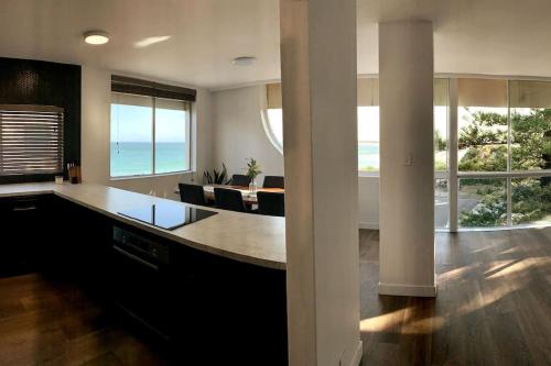 a kitchen with a large island with a view of the ocean at Ultimate Coastal Escape + Amazing Views in Caloundra