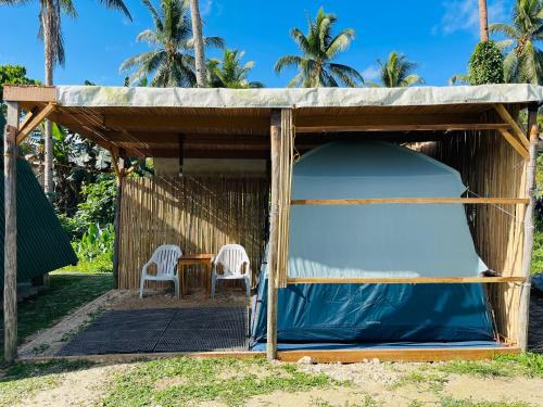 une tente avec deux chaises et une table dans l'établissement Russell Place Tent, à Port Barton