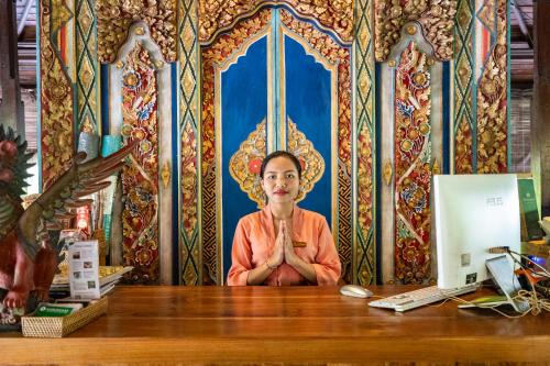 een man aan een bureau voor een computer bij Meruhdani Boutique Hotel Ubud in Ubud