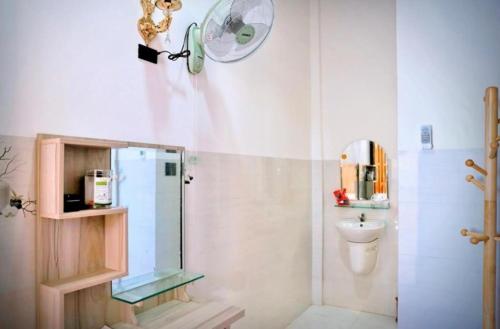 a bathroom with a shower and a toilet and a fan at Nybipu Homestay in Phan Rang