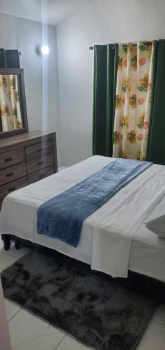 a bedroom with a large bed and a dresser at Finest Accommodation Phoenix Park Phase 4 Lot # 1348 Portmore St Catherine in Portmore