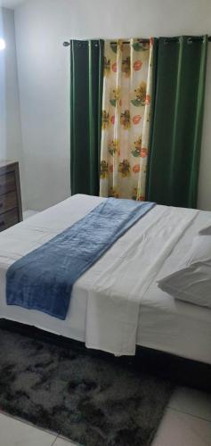 a bed with a blue blanket on top of it at Finest Accommodation Phoenix Park Phase 4 Lot # 1348 Portmore St Catherine in Portmore