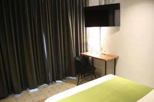 um quarto com uma secretária e uma cama e uma secretária com uma cadeira em EL PEDREGAL HOTEL em Matehuala