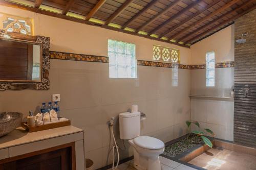 a bathroom with a toilet and a sink at Sari Bamboo Villas in Ubud