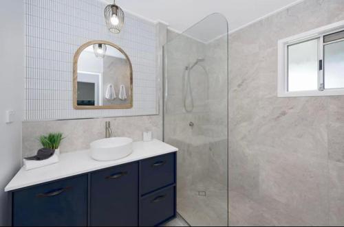 W łazience znajduje się umywalka i prysznic. w obiekcie Castle View Cottage w mieście Townsville