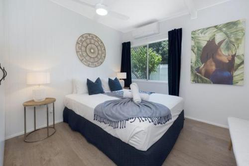 ein Schlafzimmer mit einem großen Bett und einem Gemälde an der Wand in der Unterkunft Castle View Cottage in Townsville