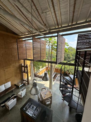 a living room with a large window and a staircase at LOFT SAJA. Diseño en tapia pisada contemporáneo in Barichara
