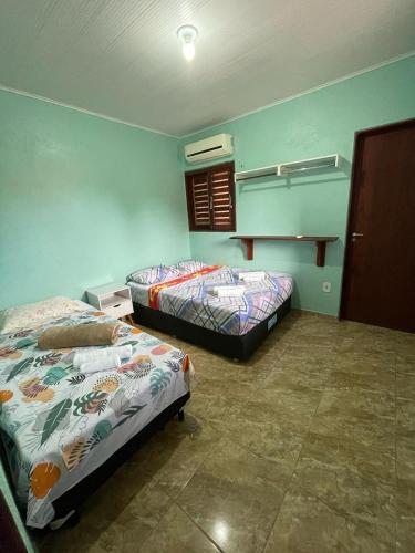 2 camas en una habitación con paredes azules en Casa de praia Amarópolis en Paripueira