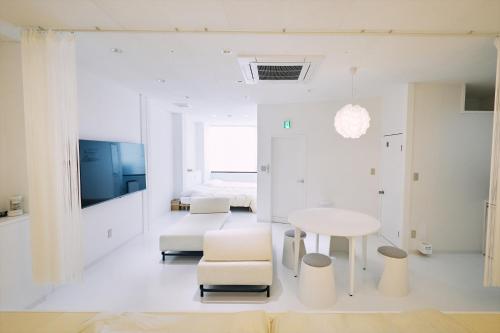 高知的住宿－「まちのアトリエ」STAY UWU 004，白色的客房配有桌子和床。