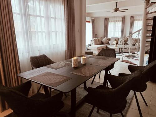 una sala da pranzo con tavolo e sedie e un soggiorno di Sea View Villa @ Nongsa Resort a Telukmataikan