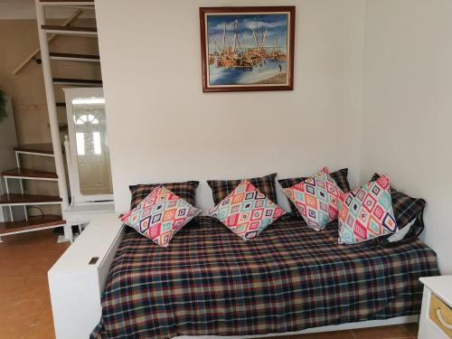 um sofá com quatro almofadas numa sala de estar em Castro Marim Al Sarita Villa em Castro Marim