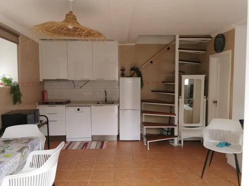 uma pequena cozinha com armários brancos e um frigorífico em Castro Marim Al Sarita Villa em Castro Marim