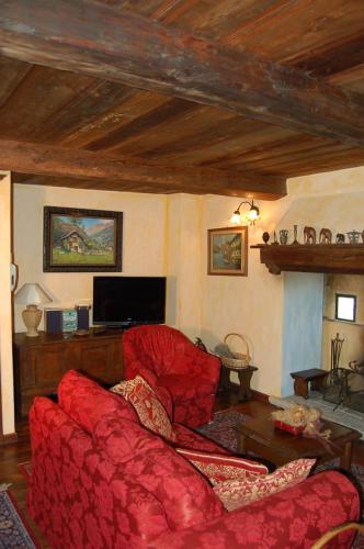 a living room with a red couch and a tv at Le Primule in Piedilago