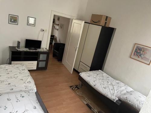 um quarto com 2 camas e uma secretária com um computador em Holländers Appartement em Bruchsal