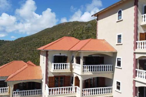 a large white building with an orange roof at 702 w/ a view at Princess Heights in Dawn Beach