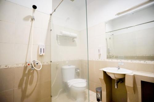 un bagno con doccia, WC e lavandino di Cakra Kusuma Hotel a Yogyakarta