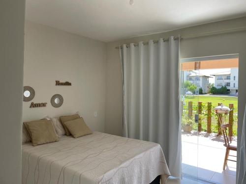 a bedroom with a bed and a view of a yard at Casa Térrea - Villa das Águas - Praia do Saco in Estância