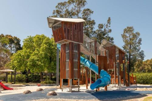 a playground with a blue slide in a park at Belmont Beauty - Relaxing Poolside Stay for Families in Perth