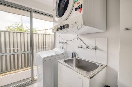 a small kitchen with a sink and a microwave at Rivervale Retreat - Spacious Family Living in Perth