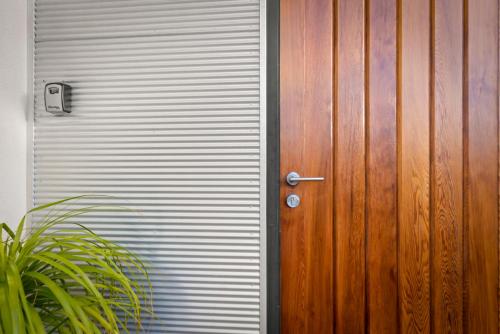 a door to a garage with a metal wall at Tree Top Views - Magnificent 4 Bedroom House - 3 Minutes to MONA in Rosetta