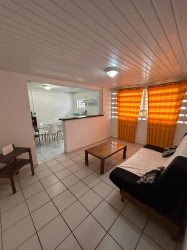 ein Wohnzimmer mit einem Sofa und einem Tisch in der Unterkunft L'escale de Paramana Ouest in Matoury