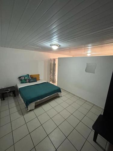 ein Schlafzimmer mit einem grünen Bett in einem Zimmer in der Unterkunft L'escale de Paramana Ouest in Matoury