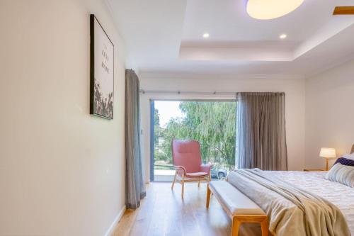 a bedroom with a bed and a chair and a window at Como Sora - A Breezy Tranquil Oasis on the Coast in Perth
