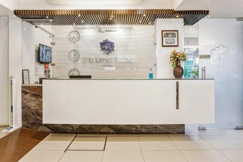 a large white counter in a room with a clock at Super Townhouse 749 The Upper Room Near Pune Airport in Lohogaon
