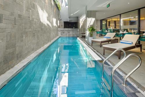 a swimming pool with blue water in a building at Satya Da Nang Hotel Han Market in Da Nang