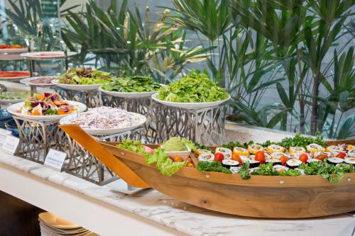 a table with plates of food in a wooden boat at Satya Da Nang Hotel Han Market in Da Nang