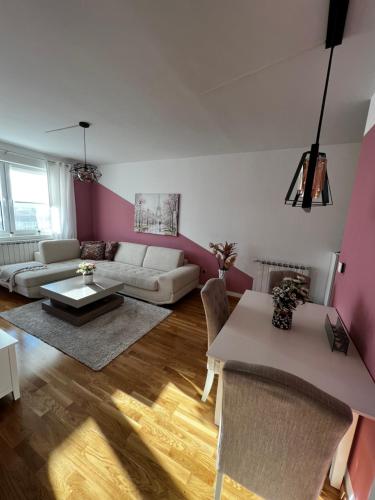 uma sala de estar com um sofá branco e paredes cor-de-rosa em Kanna Apartments - Bulevar - Free Parking em Sarajevo