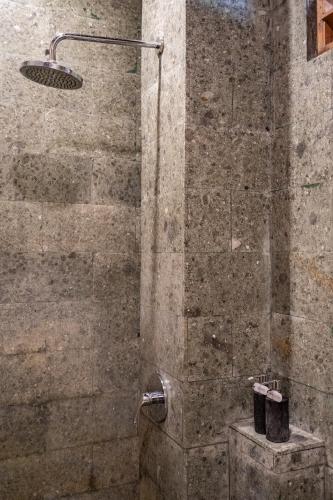 a shower with a shower head in a bathroom at Meruhdani Boutique Hotel Ubud in Ubud