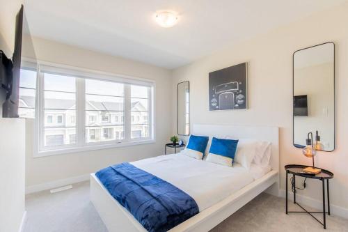 - une chambre blanche avec un lit et une fenêtre dans l'établissement Modern 3BR, 15min to Falls/Attractions W/ King Bed, à Thorold