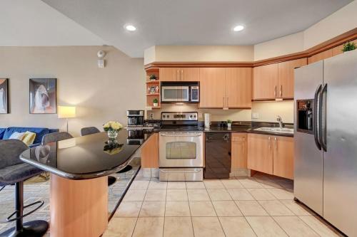 a kitchen with wooden cabinets and stainless steel appliances at Royal Oasis Suite at Platinum Hotel-Strip Views in Las Vegas