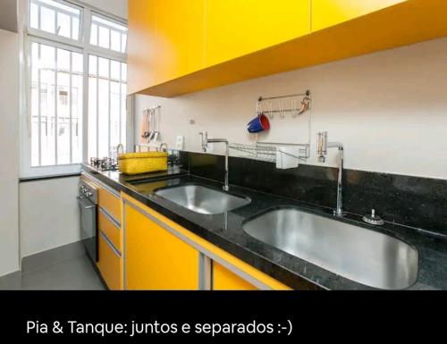 a kitchen with two sinks and a black counter top at Boa Opção Asa Sul in Brasilia