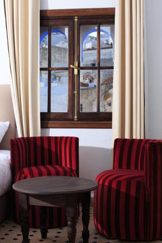a room with two chairs and a table and a window at Riad Zaitouna Chaouen in Chefchaouene