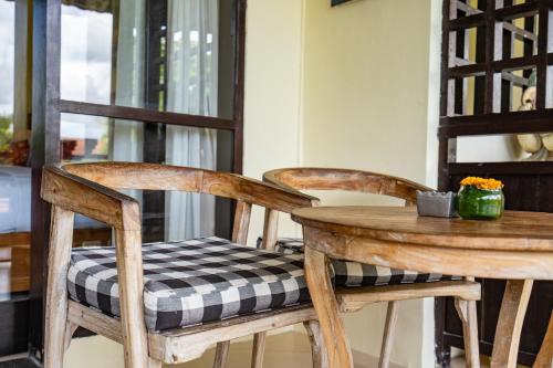 a wooden table with two chairs and a table with a seat at Meruhdani Boutique Hotel Ubud in Ubud