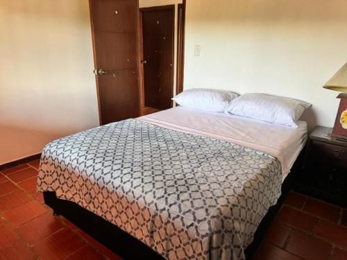 um quarto com uma cama grande com lençóis brancos e almofadas em Finca el Paraíso em Los Santos
