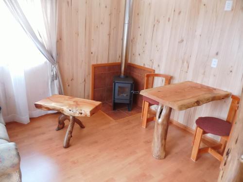 a room with a table and chairs and a stove at Cabaña Choshuenco B & B in Choshuenco