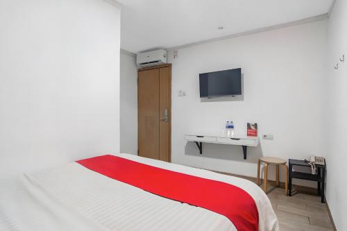 sypialnia z czerwono-białym łóżkiem i biurkiem w obiekcie Super OYO Cideng Timur Residence Near MONAS w Dżakarcie