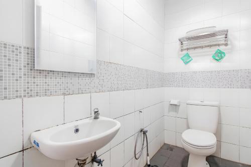 biała łazienka z umywalką i toaletą w obiekcie Super OYO Cideng Timur Residence Near MONAS w Dżakarcie