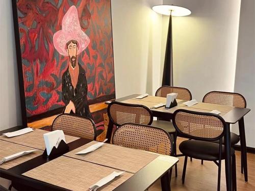 a room with tables and chairs with a painting on the wall at The Legend Fragrance Hotel- Free Deliver Service to Canton Fair Complex during Canton Fair Period in Guangzhou