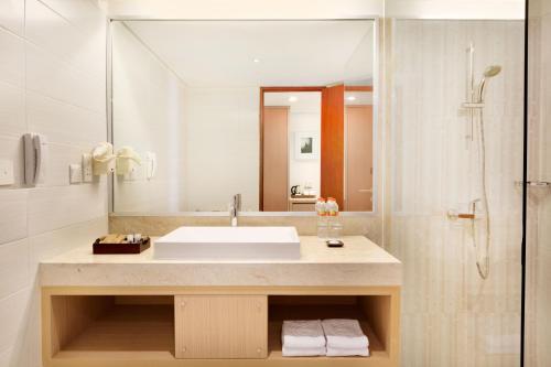 a bathroom with a sink and a shower at Ramada Encore by Wyndham Bali Seminyak in Seminyak