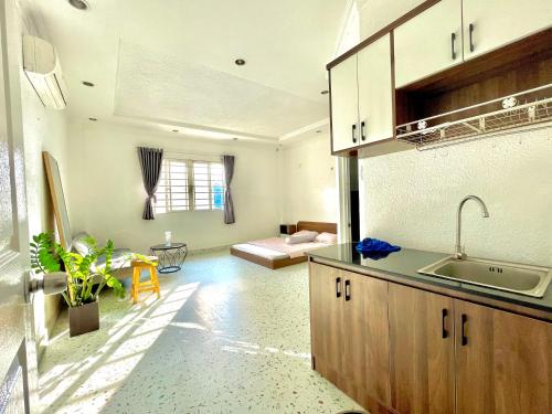 una cocina con fregadero y un sofá en una habitación en Your House en Ho Chi Minh